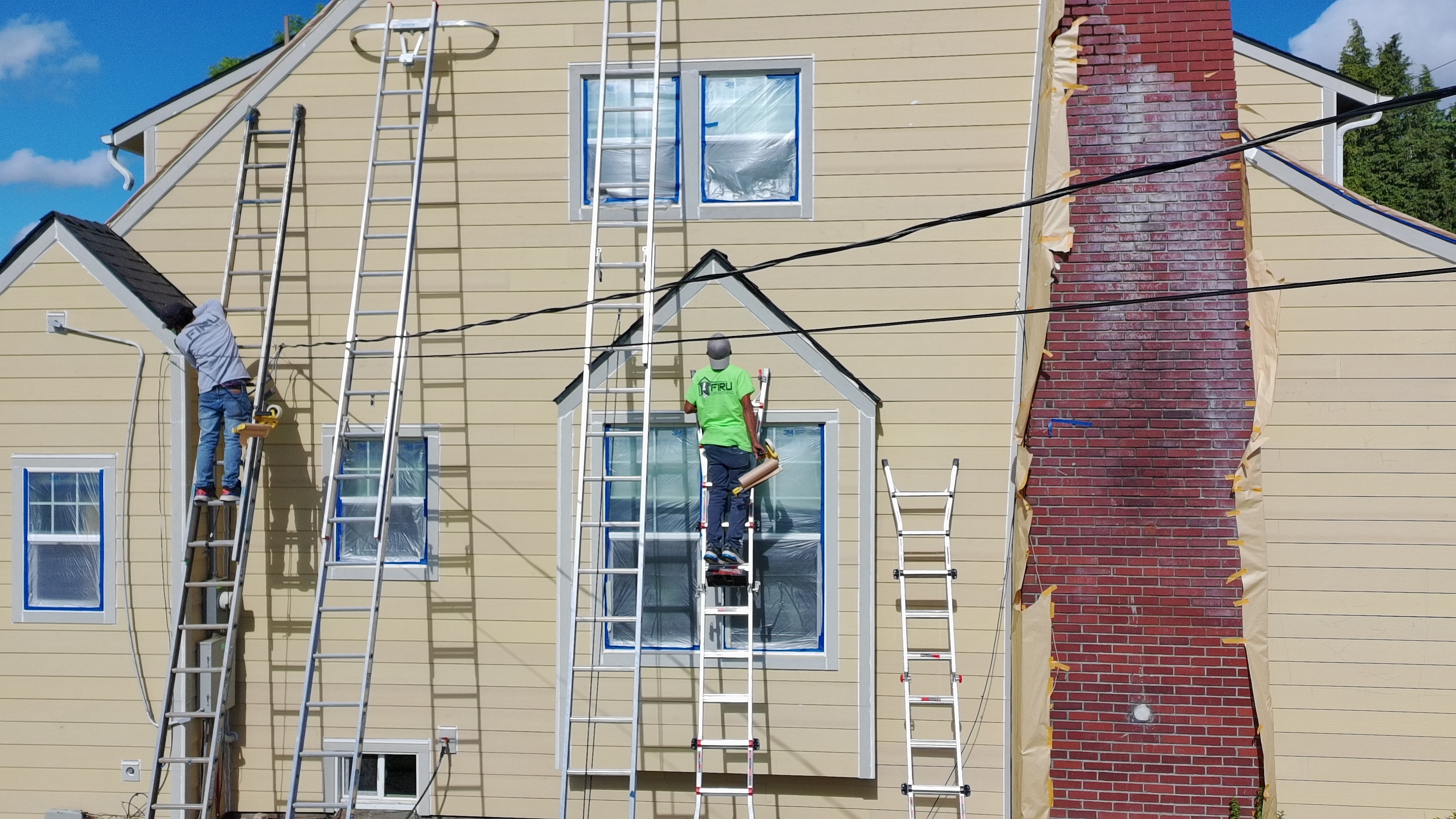 Firu Construction crew on ladders installing James Hardie siding — Stayton Oregon