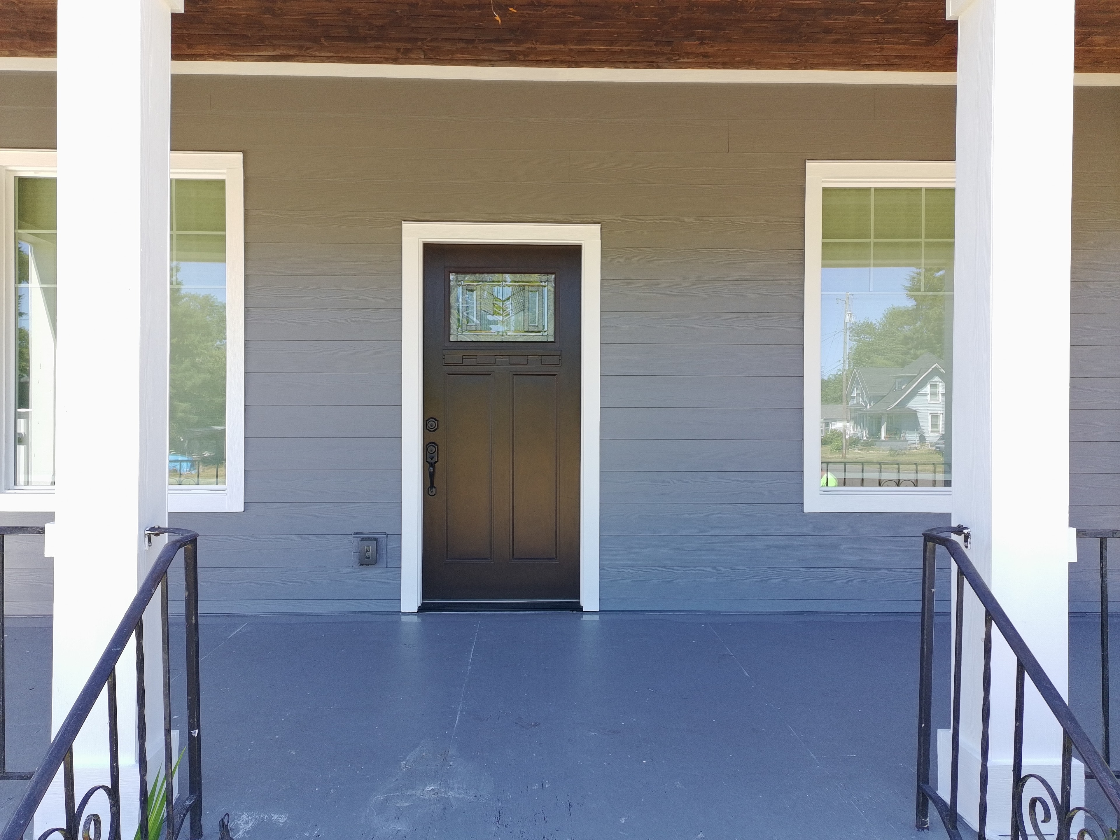 Completed front porch entry with gray James Hardie siding and dark front door — Stayton Oregon